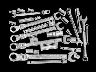 Chrome spanners and sockets arranged on a black backgroud