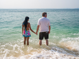Rear view of a couple standing in the sea.