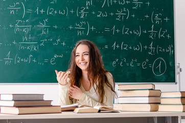 Young female math teacher in front of chalkboard