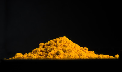 A bunch of turmeric isolated on a black background. Fragrant spice.