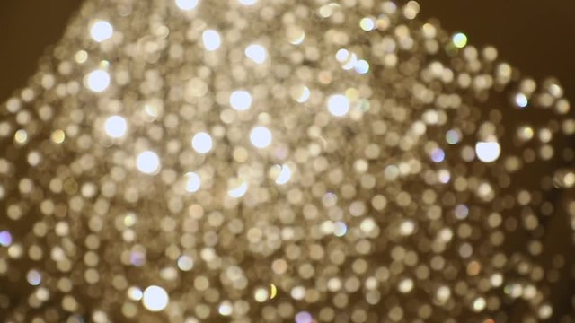 Bokeh, background slow motion medium wide shot of colorful lights, gradual shift focus to a beautiful crystal chandelier lights.