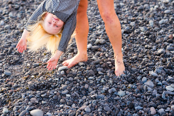 Playful concept with young children boy playin with mother holding him by feet in reverse position