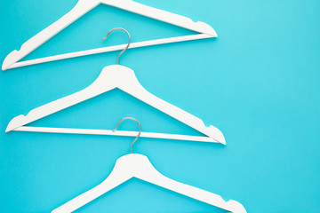 White wooden hangers on blue background