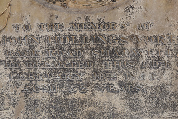 An Old Gravestone surface with text letters on it, close up