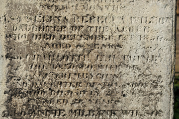 An Old Gravestone surface with text letters on it, close up