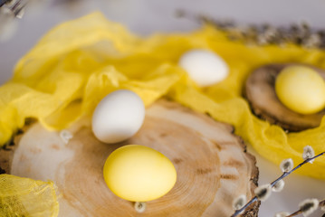 Sunny Easter photo. The photo shows willow twigs, wooden cuts, yellow and white Easter eggs.
