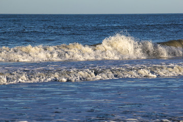 a big wave is splashing in a blue sea and a blue background