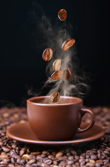 Roasted coffee beans falling into coffee cup