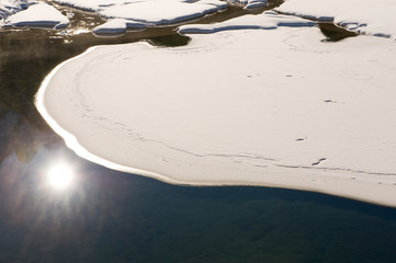 Residual snow cover on a mountain lake.
