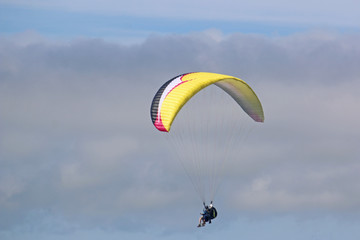 Tandem paraglider flying yellow wing