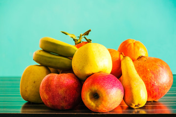 Winter fruits of Provence in the room on the table against the background of the green mint wall.