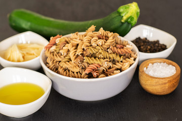 Set of ingredients. recipe step by step fusilli pasta with zucchini on grey stone