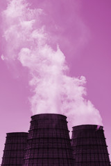 Three big tower of CHPP close-up. Steam from wide pipe of CHP on sky. Industrial background of TPP in pink tones with copy space. Huge pipes of thermal power plant produce steam for electric power.