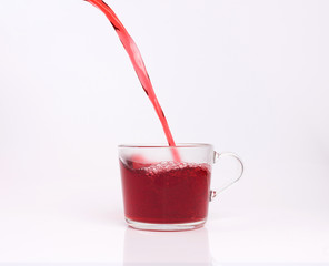 Fruit tea pouring in the cup isolated on white background