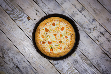 A whole big pizza close-up on a gray background. Colorful pizza topping closeup