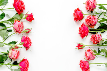 Flower border frame made of red roses on white background with copy space for text. Valentine's background. Floral pattern. Flat lay, top view. 
