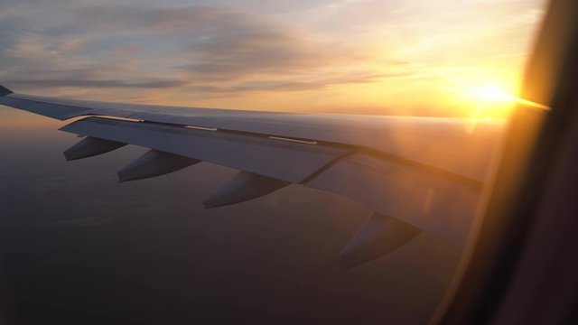 sunset in the window of the plane. beautiful view of the aircraft wing. passenger transportation and travel
