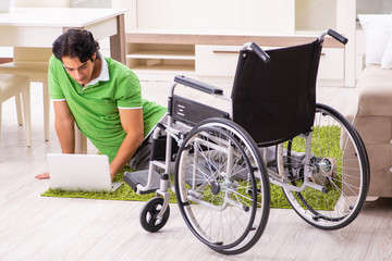 Young handsome man in wheelchair at home