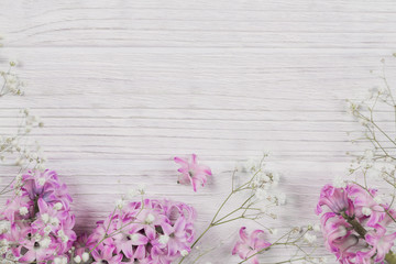 Abstract composition of fresh purple hyacinths on a white rustic wooden background. Pattern of different flowers