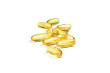 Close up of pile fish oil capsules isolated on white background. Supplementary food background. Omega 3. Vitamin E.