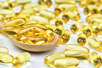 close up of Fish oil capsules in wood spoon. Supplementary food. Vitamin E. Vitamin D.
