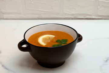 Turkish red lentil cream soup on neutral background.