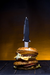 The knife is embedded in a burger. Hunting knife in a burger.