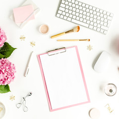 Stylized women's desk. Workspace with clipboard, computer, bouquet hydrangea, accessories on white background. Flat lay. Top view.