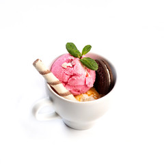 Ice cream decorated with mint and sweets in a cup on an isolated white background