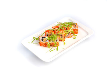 Set sushi rolls on a rectangular white plate on an isolated white background