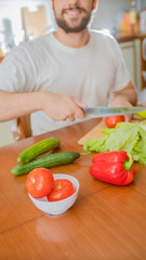 a man cooks in the kitchen he cuts vegetables
