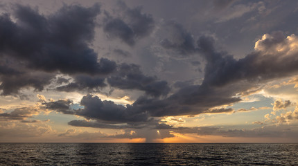Fototapeta premium Abstract seascape panoramic background - Orange color in the sky, sunset late afternoon. Calm seas/ocean in the bottom of the frame. Minimalistic simple background image, blue and yellow colors.