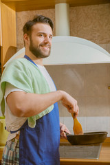 a man cooks in the kitchen he cuts vegetables