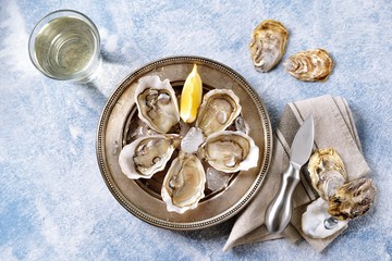 Fresh ocean oysters with slices of lemon on ice. 