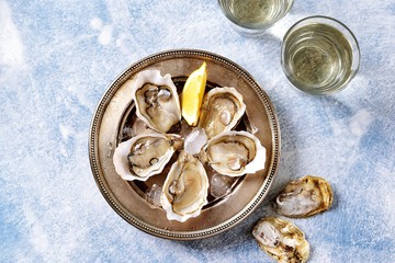 Fresh ocean oysters with slices of lemon on ice. 