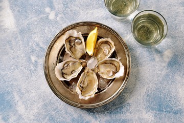 Fresh ocean oysters with slices of lemon on ice. 