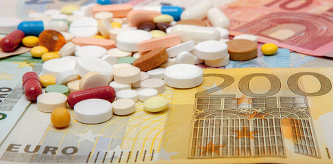 Money and pills. Pills of different colors on money. medicine concept. Euro cash