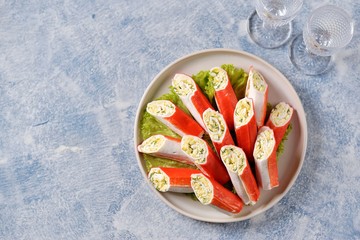 Crab sticks stuffed with soft cheese, boiled egg, garlic, mayonnaise and dill. Festive Russian snack. Top view.  © chudo2307