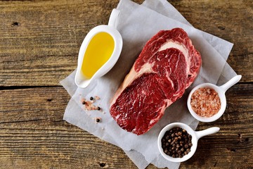 Raw fresh beef steak rib eye on old wooden background. Rustik Style. Top view.