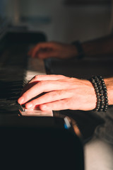 mani di un uomo che suonano il pianoforte
