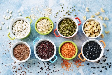 Red lentils, peas, black, white and red beans, nuts - the concept of healthy vegetarian food. Top view. 
