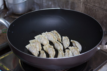 fried dumplings Gyoza with pork stuff during cooking on a pan