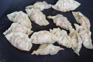 fried dumplings Gyoza with pork stuff during cooking on a pan
