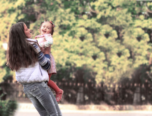 Fototapeta na wymiar Smiling mother and little daughter on nature. Happy people outdoors
