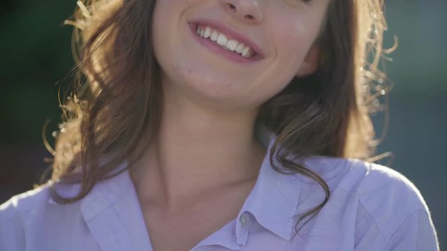 Close-up shot of pretty young Caucasian female mouth outside, laughing. Front view. Lifestyle concept