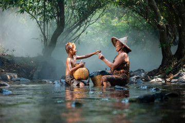 Asaia old lady and child boy fishing on river stream nature in countryside of living life farmer rural