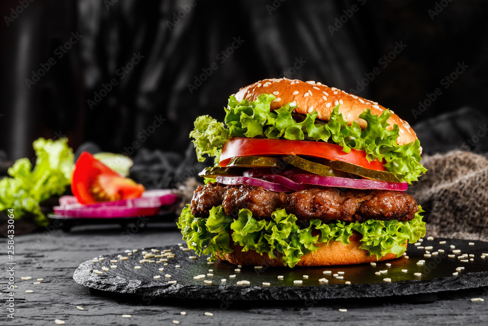 Canvas Prints beef burger with tomatoes, red onions, cucumber and lettuce on black slate over dark background. unh