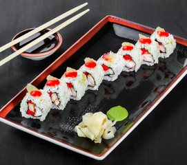 Sushi Roll - Maki Sushi with sea kale, Crab meat, avocado, cream cheese on dark wooden background. Top view. Japanese cuisine