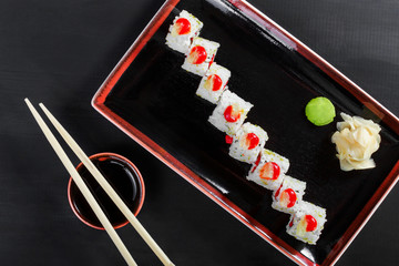 Sushi Roll - Maki Sushi with sea kale, Crab meat, avocado, cream cheese on dark wooden background. Top view. Japanese cuisine