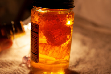 fresh amber local honey in a jar with wax honey comb cells inside